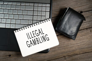 A paper displaying ‘illegal gambling’ on the keyboards of a pc.