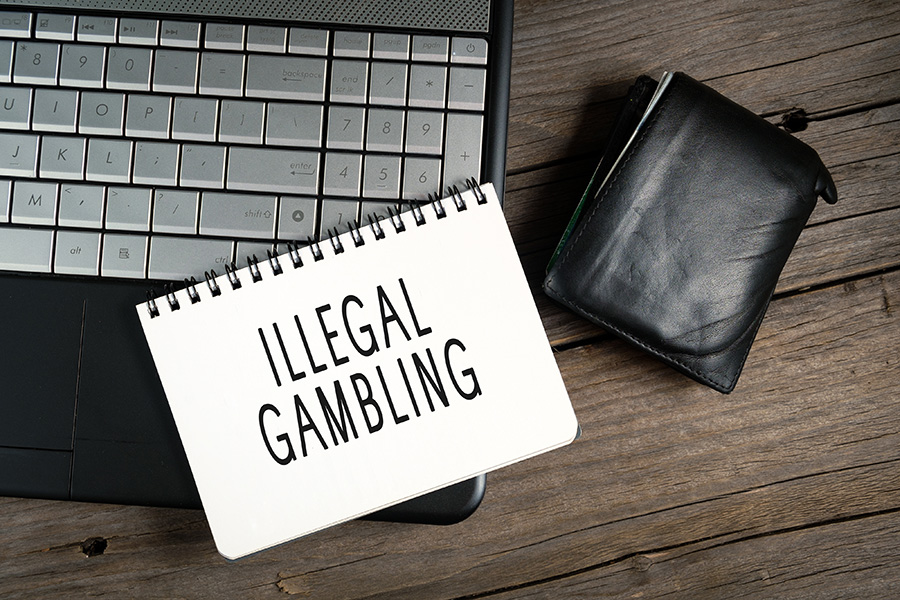A paper displaying ‘illegal gambling’ on the keyboards of a pc.