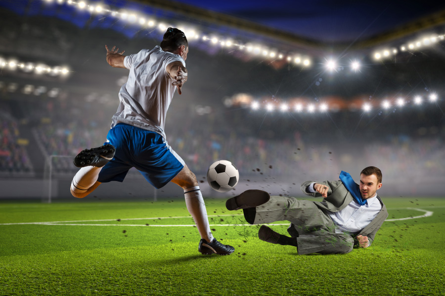 Two individuals playing football on a field.