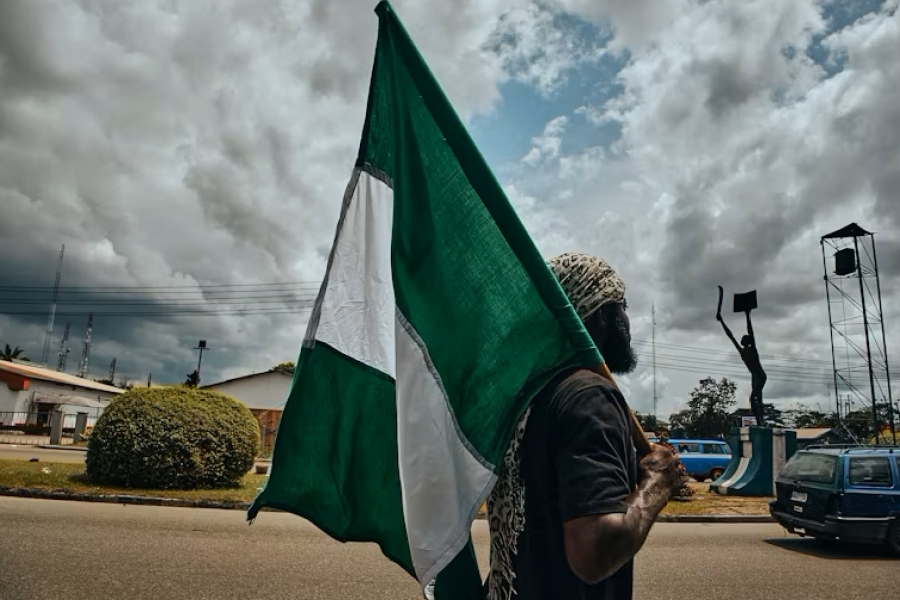 The flag of Nigeria being held by a man.