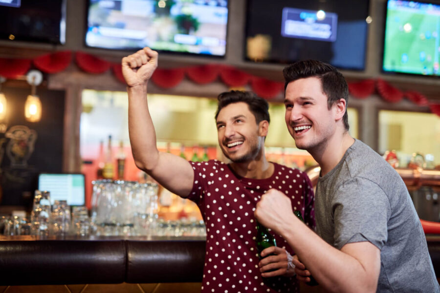 Men celebrating sports betting with betting license in South Africa.