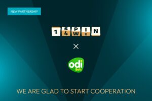A promotional graphic announcing a ‘NEW PARTNERSHIP’ between 1spin4win and Odibets. The design features the 1spin4win logo, styled as ivory-coloured cubes, positioned above a white cross symbol and the Odibets logo. The text ‘WE ARE GLAD TO START COOPERATION’ is displayed in gold lettering at the bottom against a dark teal background with geometric light beams.