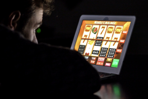 Photo of a man gambling on a computer.