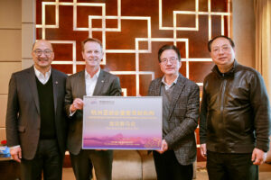 HKJC's executives, Andrew Harding and Raymond Tam, received a plaque from the deputy mayor of Hangzhou and HAGOC commander of equestrian events. Credit: HKJC.