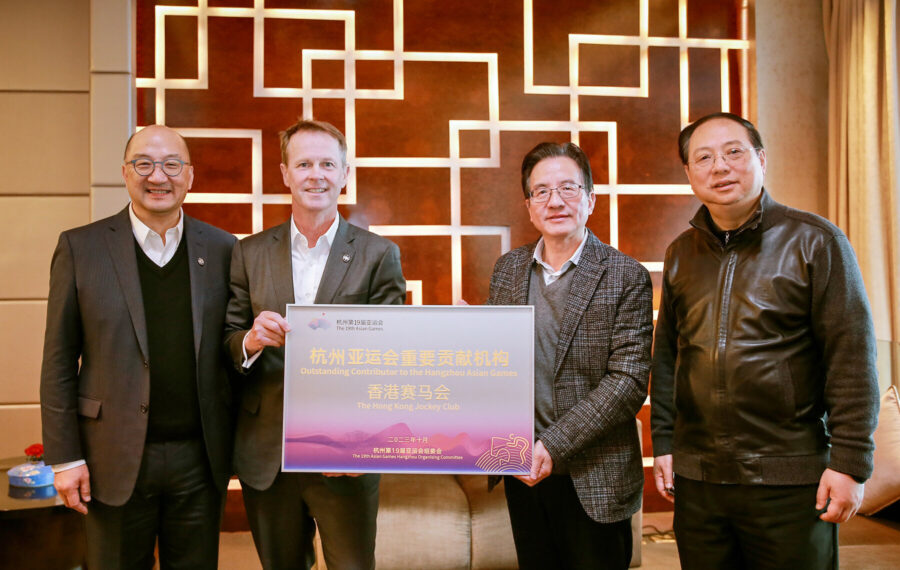 HKJC's executives, Andrew Harding and Raymond Tam, received a plaque from the deputy mayor of Hangzhou and HAGOC commander of equestrian events. Credit: HKJC.