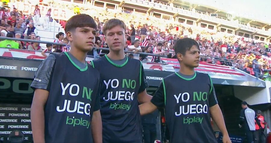 Los alcanzapelotas con las pecheras con la consigna contra el juego juvenil.