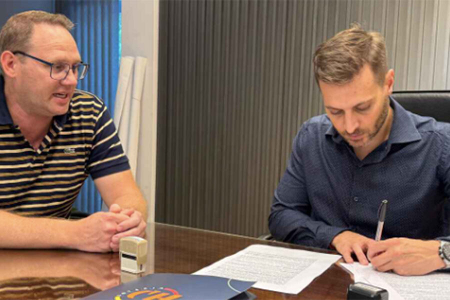 El presidente de Lotería Chaqueña, Lucas Apud Masín, y el titular del Club Social de Las Breñas, Sebastian Pertile, firman un acuerdo. Foto: Lotería Chaqueña.