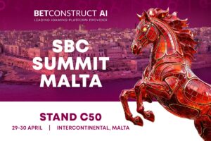Imagen promocional de BetConstruct AI en la SBC Summit Malta, celebrada en el Intercontinental Malta los días 29 y 30 de abril de 2026. El fondo muestra una vista panorámica de una ciudad costera maltesa teñida de rosa y morado. En primer plano, se ve una gran estatua de un caballo en 3D, decorada con segmentos de mosaico en tonos rojos y dorados, encabritándose. El texto destaca a BetConstruct como proveedor líder de plataformas de iGaming e indica «STAND C50» como su ubicación.