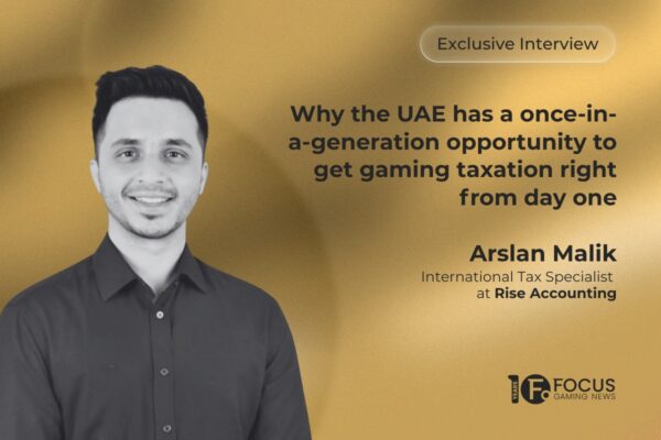 A promotional interview graphic. On the left side, a black-and-white portrait features Arslan Malik. In the upper right, an outline contains the text ‘Exclusive Interview’. Below this, the main headline is written in bold, dark grey letters: ‘Why the UAE has a once-in-a-generation opportunity to get gaming taxation right from day one’. Malik’s name and his job title, ‘International Tax Specialist at Rise Accounting’, are printed in dark grey towards the bottom right, and the Focus Gaming News logo is positioned in the bottom-right corner.
