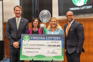 Governor Youngkin receives a check from Lottery executive director Khalid Jones.