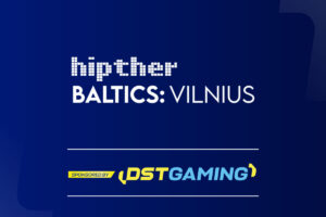 Here is the British English Alt Text for this promotional graphic: **Alt Text:** A promotional banner for the 'Hipther Baltics: Vilnius' event on a dark blue gradient background. The 'hipther' logo appears in a white pixelated font above the text 'BALTICS: VILNIUS' in white capital letters. A 'SPONSORED BY' section at the bottom features the DSTGAMING logo in yellow and light blue.