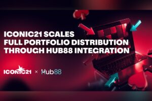 A promotional graphic announcing that ‘ICONIC21 SCALES FULL PORTFOLIO DISTRIBUTION THROUGH HUB88 INTEGRATION’. The design features a laptop on the right being targeted by several 3D red and teal arrows, symbolising digital integration. Floating 3D card suit icons, including a heart and a club, are scattered around the device against a dark background with a vibrant red glow. The ICONIC21 and Hub88 logos are positioned in the bottom-left corner.