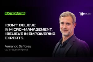 A quote graphic featuring a headshot of Fernando Saffores, CEO of Focus Gaming News, against a dark purple gradient background. The text on the left reads: ‘I don't believe in micro-management. I believe in empowering experts.’ The Slotegrator logo is positioned in the top-left corner, and the Focus Gaming News logo is in the top-right.