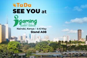Here is the British English Alt Text for this promotional image: **Alt Text:** A promotional banner for the iGaming Afrika Summit 2026 featuring the TaDa logo. The background is a panoramic view of the Nairobi skyline overlooking a lush green park and lake. The text reads 'SEE YOU at iGaming Afrika Summit | NAIROBI', with details for Nairobi, Kenya, from 4-6 May, at Stand A08.