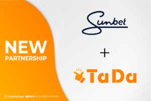 A ‘New Partnership’ announcement graphic for Sunbet and TaDa Gaming. The left side features a bold orange curved section with the text ‘NEW PARTNERSHIP’ in white capital letters. On the right, the Sunbet and TaDa logos are displayed, separated by a plus sign, against a light grey background with subtle curved lines. Small regulatory logos for GambleAware and the MGA are included at the bottom.