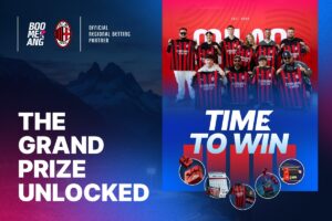 A promotional graphic divided into two main vertical sections. The left side features a dark blue backdrop showing a silhouette of jagged mountain peaks at dusk, with the bold white text ‘THE GRAND PRIZE UNLOCKED’. At the top left, the Boomerang Partners logo stands next to the AC Milan club crest, accompanied by the text ‘OFFICIAL REGIONAL BETTING PARTNER’. The right side has a vibrant red and blue gradient background where a group of nine people are smiling and posing together, each holding up a red-and-black striped AC Milan football shirt featuring the ‘Emirates FLY BETTER’ sponsor logo. Below the group portrait, the large headline reads ‘TIME TO WIN’ in white text.