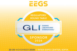 A promotional graphic for the EEGS event, identifying Gaming Laboratories International (GLI) as the sponsor for the ‘REGULATORS’ ROUND TABLE’. The design features a circular gold and white emblem in the centre, with the GLI logo overlaid in a white rectangular box. The ‘EEGS’ logo is positioned at the top in gold lettering. The bottom of the image displays the event details: ‘25–26 NOVEMBER 2026’ at the ‘INTER EXPO CENTER, SOFIA’. The background consists of a bright yellow gradient patterned with small white crosses.