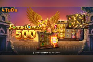 A promotional graphic for the online slot game ‘Fortune Garuda 500’ by TaDa Gaming, set against a sunset backdrop over an ancient stone temple. The game’s title is displayed on the left in large, gold 3D lettering with embedded blue and green gems. In the centre, a muscular, golden Garuda mythical bird creature spreads its feathered wings. The orange TaDa logo is at the top left, and licensing information, including GambleAware and MGA, is positioned along the bottom.