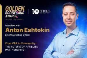 A promotional interview graphic. On the right, a colour portrait features Anton Eshtokin. In the top-left corner, the ‘GOLDEN BOOMERANG AWARDS 2026’ logo is displayed with the tagline ‘BEYOND THE MOMENT’, separated by a white vertical line from the Focus Gaming News logo. Below this, a text reads ‘Interview with’, followed by ‘Anton Eshtokin’ in large gold letters and his title ‘Chief Marketing Officer’ in white. Towards the bottom left, the feature title is written in a mix of gold and white capital letters: ‘From CPA to Community: THE FUTURE OF AFFILIATE PARTNERSHIPS’.
