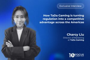 A promotional interview graphic set. On the left side, a black-and-white portrait features Charcy Liu, Director of Marketing at TaDa Gaming. In the upper right, a white pill-shaped outline contains the text ‘Exclusive Interview’. Below this, the main headline is written in bold white letters: ‘How TaDa Gaming is turning regulation into a competitive advantage across the Americas’. The Focus Gaming News logo is positioned in the bottom-right corner.